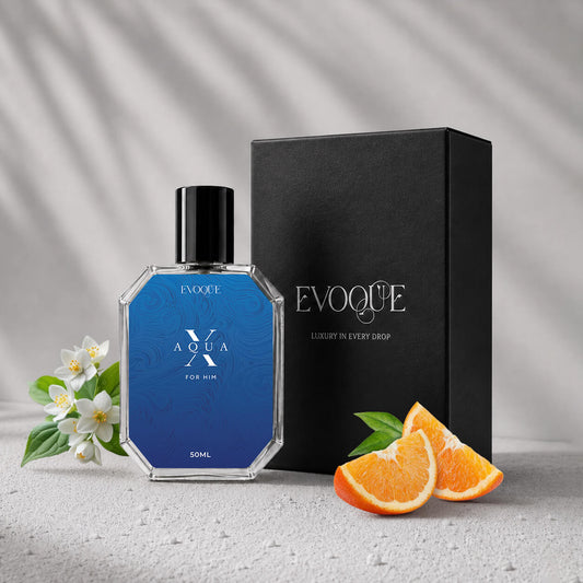 Evoque Aqua X perfume bottle with packaging and oranges on a light background